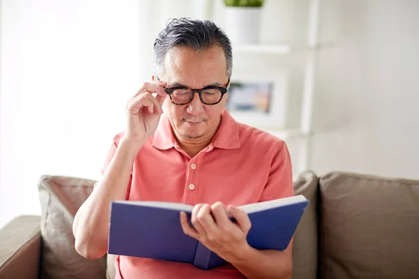 Hombre en gafas libro de lectura en casa — Foto de Stock