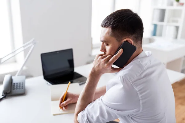 Hombre de negocios llamando en teléfono inteligente en la oficina — Foto de Stock