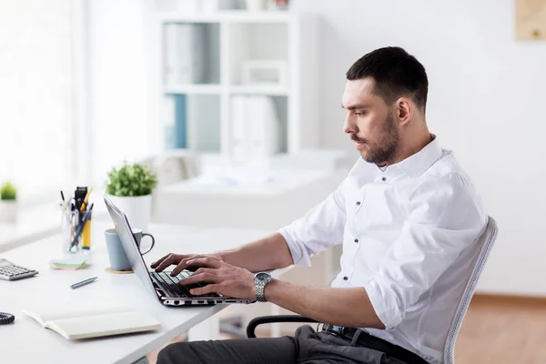 Homme d'affaires tapant sur ordinateur portable au bureau — Photo