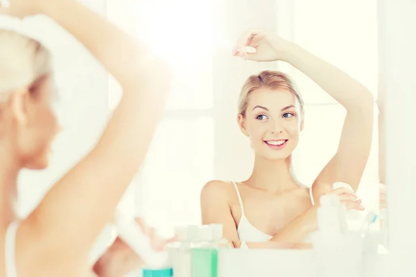 Femme avec déodorant antisudorifique à la salle de bain — Photo