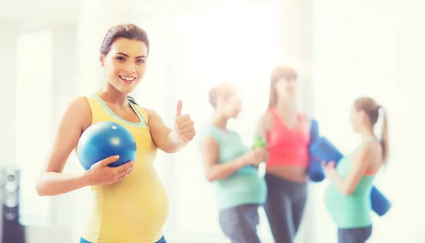 Έγκυος γυναίκα με μπάλα στο γυμναστήριο, δείχνει τους αντίχειρες επάνω — Φωτογραφία Αρχείου