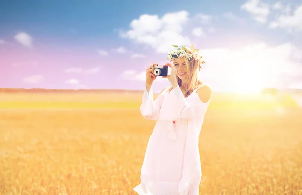 Mulher feliz com câmera de filme na grinalda de flores — Fotografia de Stock