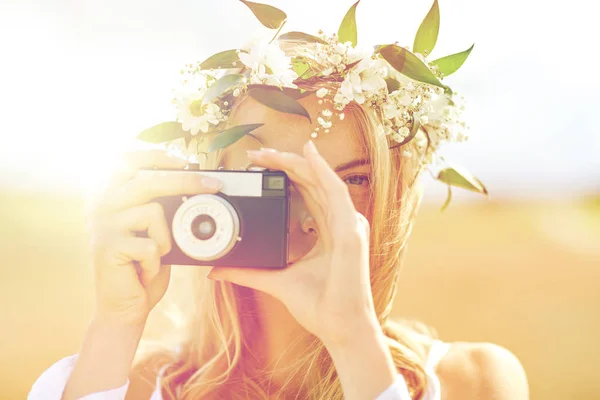 Szczęśliwa kobieta z kamerą filmową w wieńcu kwiatów — Zdjęcie stockowe