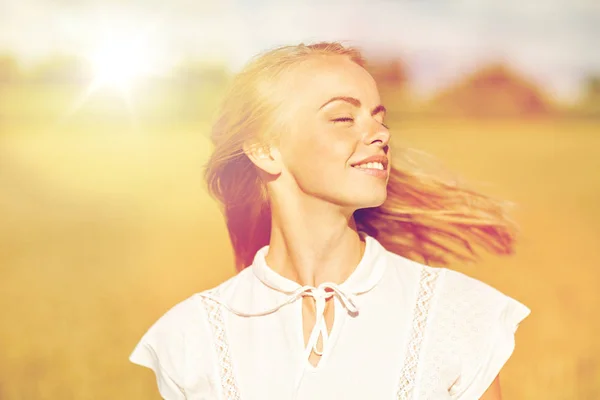 Sorrindo jovem mulher em branco no campo de cereais — Fotografia de Stock