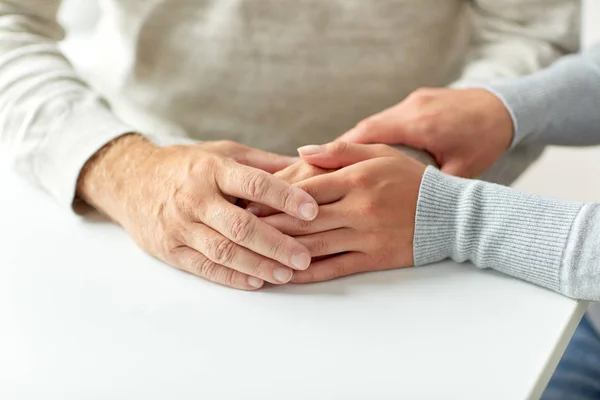 Nahaufnahme eines alten Mannes und einer jungen Frau beim Händchenhalten — Stockfoto