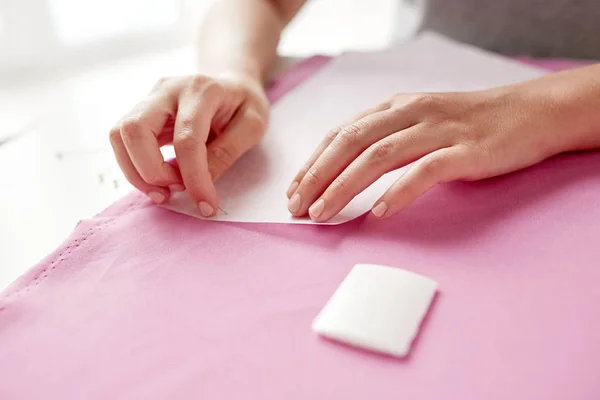 Kobieta ze szpilkami do szycia wzór papieru do tkaniny — Zdjęcie stockowe