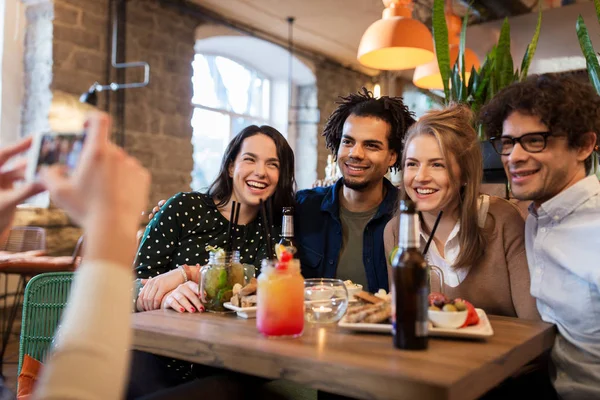 Amigos con smartphone fotografiando en la cafetería — Foto de Stock