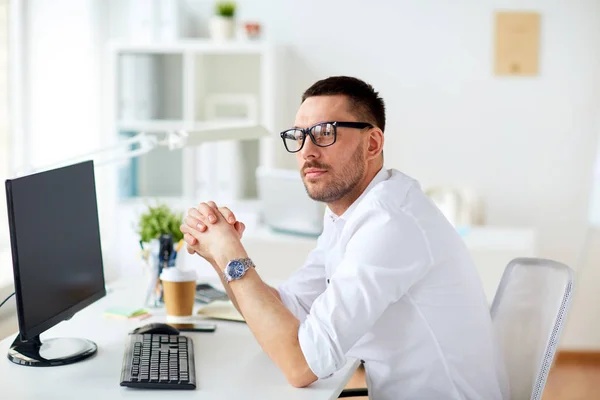 Zakenman in glazen achter computer op kantoor — Stockfoto