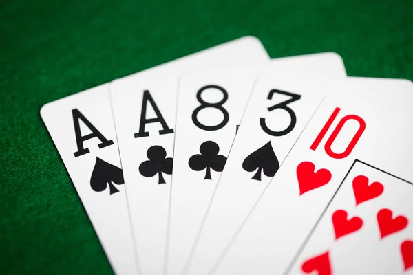 Mão de poker de jogar cartas no pano de casino verde — Fotografia de Stock