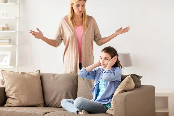Girl closing ears to not hear angry mother at home — Stock Photo, Image