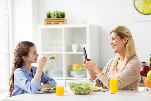 Mulher fotografar filha por smartphone em casa — Fotografia de Stock