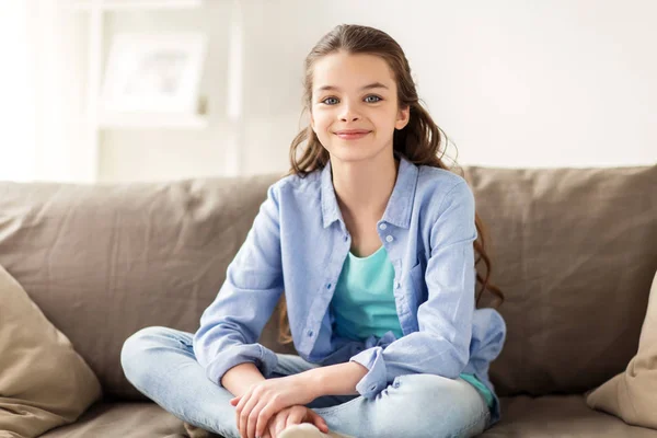 Gelukkig lachend preteen meisje, zittend op de Bank thuis — Stockfoto