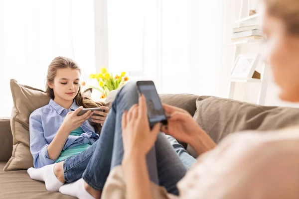 Família feliz com smartphones em casa — Fotografia de Stock