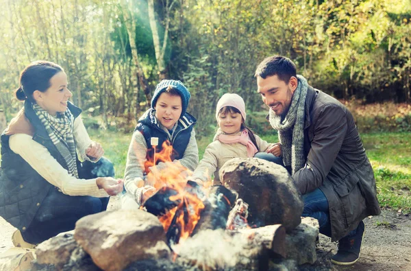 Marshmallow roosteren boven kampvuur en gelukkige familie — Stockfoto