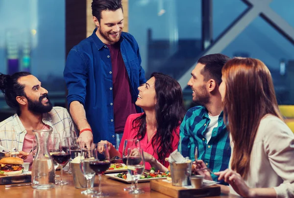 Přátelé stolování a pití vína v restauraci — Stock fotografie