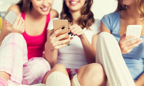 Amigos o chicas adolescentes con teléfonos inteligentes en casa —  Fotos de Stock
