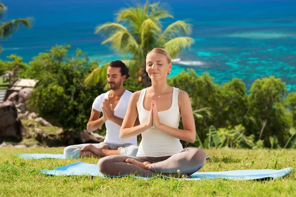 Happy couple doing yoga and meditating outdoors — Stock Photo, Image