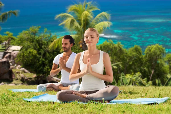 Pareja feliz haciendo yoga y meditando al aire libre —  Fotos de Stock