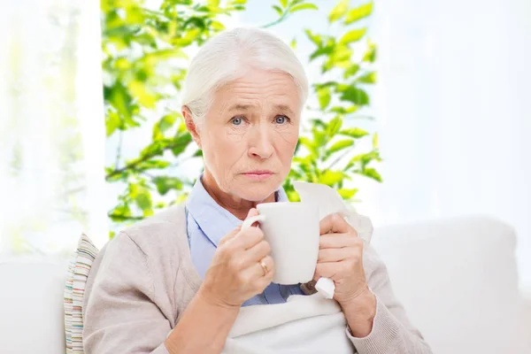 Nemocný starší žena pít horký čaj doma — Stock fotografie
