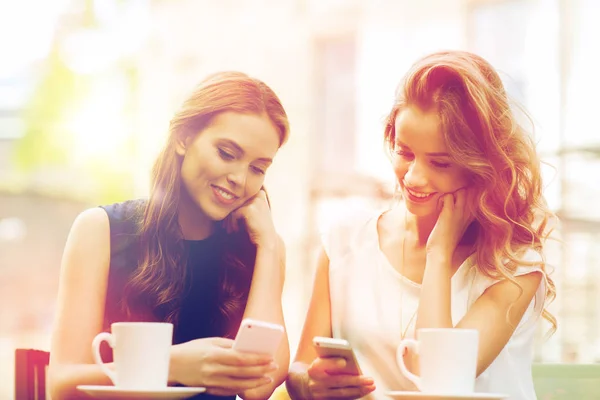 Mujeres con teléfonos inteligentes y café en la cafetería al aire libre —  Fotos de Stock
