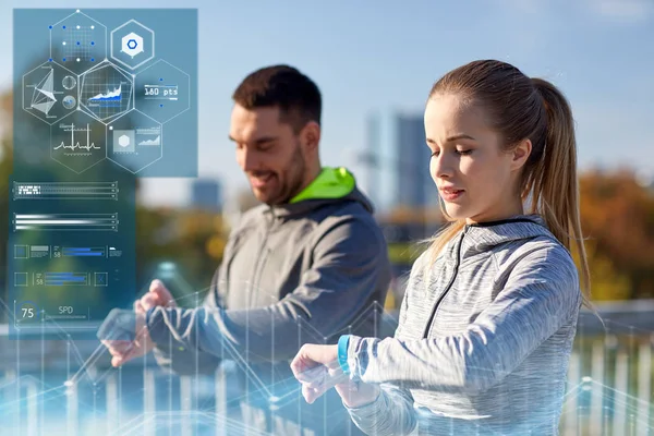 Couple with heart-rate trackers training outdoors — Stock Photo, Image