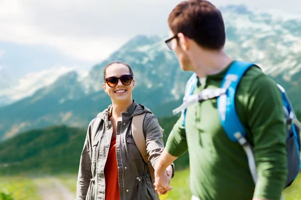 Feliz pareja con mochilas que viajan en las tierras altas — Foto de Stock