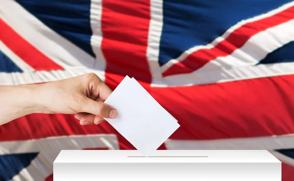 Mano del inglés con boleta y caja de votación en las elecciones — Foto de Stock