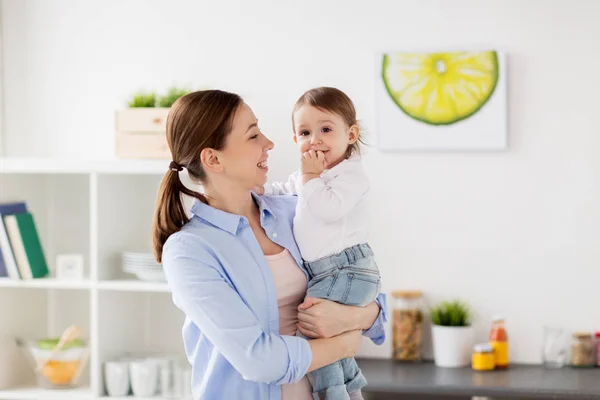 Счастливая мать и маленькая девочка на домашней кухне — стоковое фото
