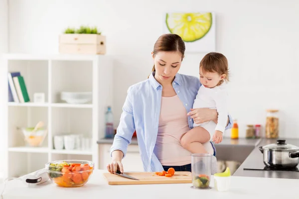 Feliz madre y bebé cocina comida en casa cocina —  Fotos de Stock