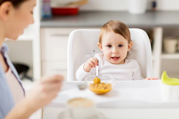 Feliz madre y bebé desayunando en casa — Foto de Stock