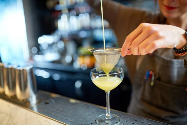 Barman giet cocktail in glas aan de bar — Stockfoto
