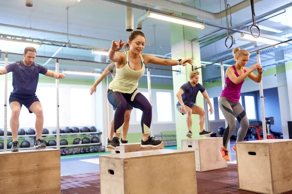 Grupo de pessoas fazendo caixa salta exercício no ginásio — Fotografia de Stock