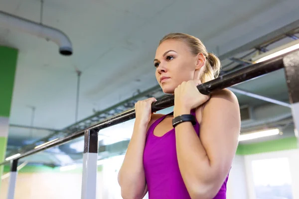 Kvinna utövar och göra pull-ups i gymmet — Stockfoto