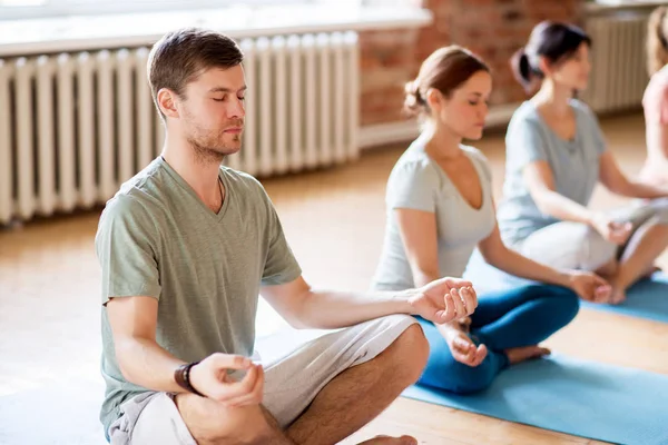 Gruppo di persone che fanno esercizi di yoga in studio — Foto Stock