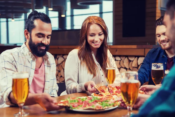 Друзі їдять піцу з пивом в ресторані — стокове фото