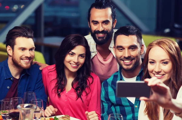 Vrienden nemen selfie door smartphone bij restaurant — Stockfoto