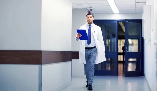 Γιατρός με πρόχειρο περπατώντας νοσοκομείο — Φωτογραφία Αρχείου