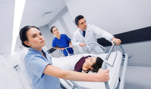 Lääkärit naisen kanssa sairaalapaareilla hätätilanteessa — kuvapankkivalokuva