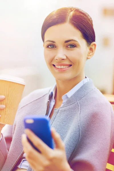 Χαμογελαστή γυναίκα με καφέ και smartphone — Φωτογραφία Αρχείου