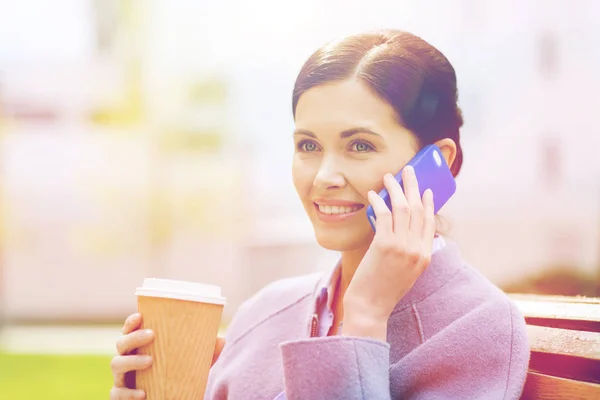 Lachende vrouw met koffie bellen op smartphone — Stockfoto