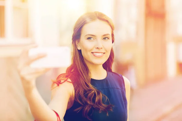 Gelukkige vrouw die selfie met smartphone in stad — Stockfoto