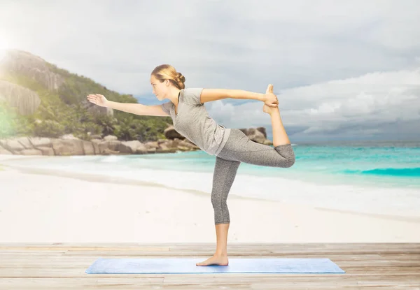 Kvinna i yoga lord of dance Posen på stranden — Stockfoto