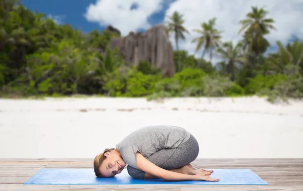 Donna felice che fa yoga in posa bambino sulla spiaggia — Foto Stock