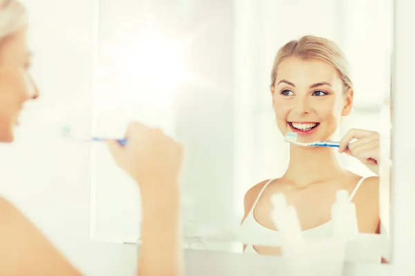 Donna con spazzolino da denti pulizia dei denti in bagno — Foto Stock