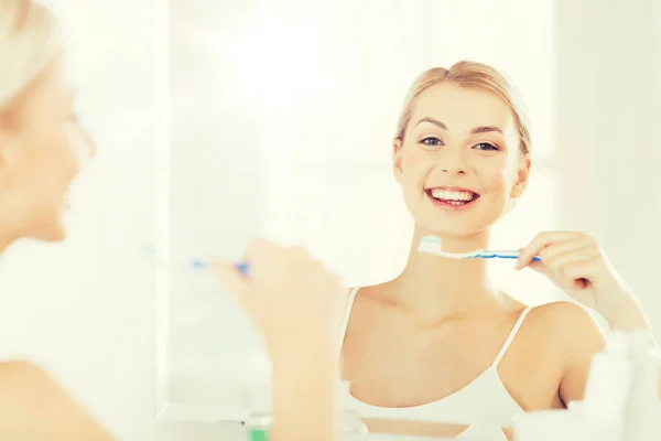 Kvinna med tandborste rengöring tänder på badrum — Stockfoto