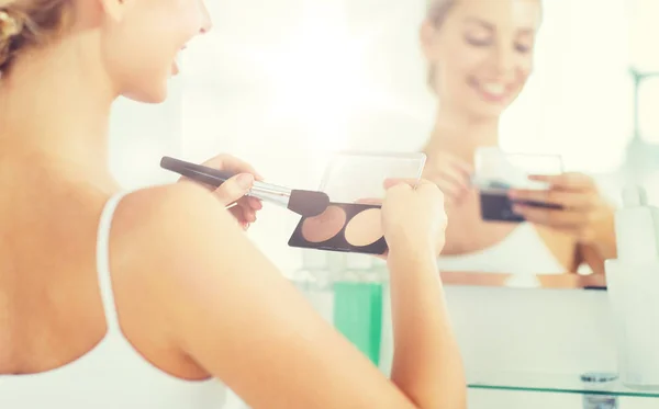 Vrouw met make-up borstel en Stichting op badkamer — Stockfoto