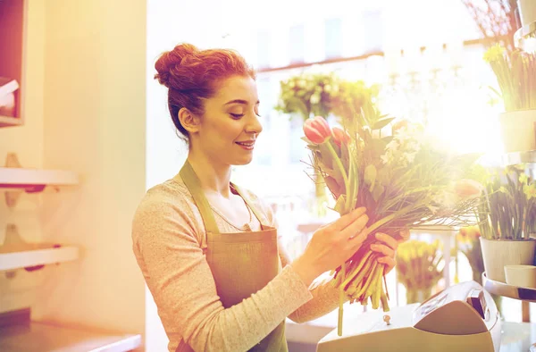 Sonriente florista mujer haciendo ramo en floristería — Foto de Stock
