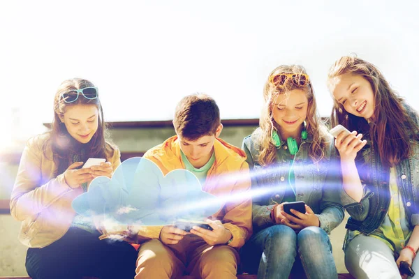 Amigos adolescentes felizes com smartphones ao ar livre — Fotografia de Stock