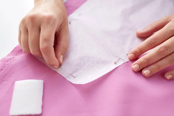Vrouw met pinnen stiksel papier patroon om stof — Stockfoto