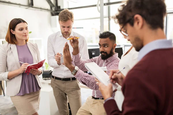 Equipe de negócios feliz discutindo algo no escritório — Fotografia de Stock